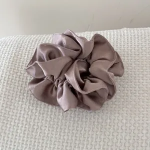 Vue détaillée d'un chouchou en satin à double épaisseur avec volants en mauve élégant