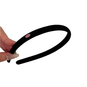 Elegant black suede narrow headband for women featuring a minimalist pink 'Love' label