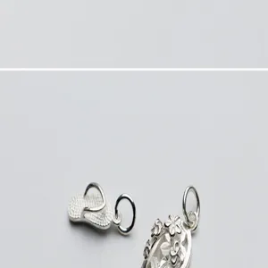 Detailed macro shot of S925 sterling silver flip-flop and flower charms for DIY jewelry