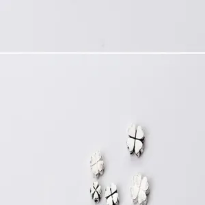 Close-up view of silver four-leaf flower spacer beads for DIY jewelry making.