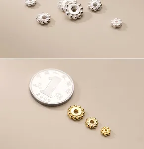 Dettaglio di distanziatori in argento e oro S925 con una moneta per riferimento