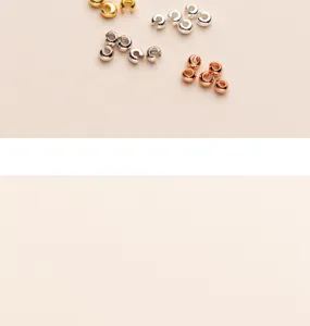 Nahaufnahme von vergoldeten S925 Silber-Quetschperlen in Gold, Silber und Roségold-Finish.