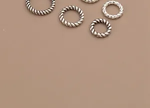 Detailed macro shot of vintage S925 Thai silver twisted jump rings for DIY jewelry