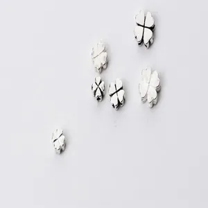 Macro view of S925 sterling silver four-leaf clover spacer beads for handmade DIY jewelry