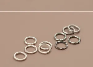 Macro detail of S925 sterling silver twisted rope jump rings for DIY jewelry creation.