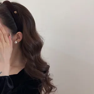 Serre-tête élégant en velours marron avec petit cœur doré porté par un mannequin pour femme