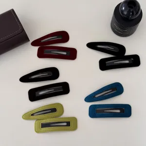 Diverses pinces à cheveux BB géométriques en velours coloré, formes goutte et rectangle.