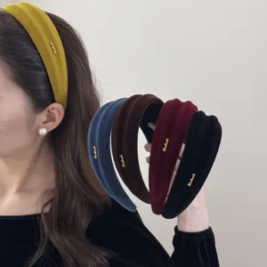 Dettaglio di vari cerchietti in velluto colorati con scritte dorate molto eleganti