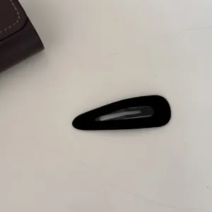 Vue détaillée d'une pince à cheveux classique en velours noir avec un fini mat élégant.