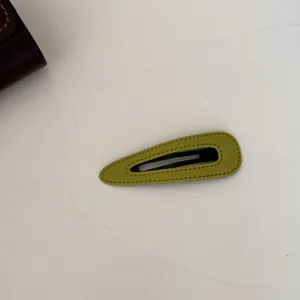 Vue détaillée d'une barrette à cheveux en velours vert avec des surpiqûres décoratives