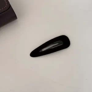 Détail de la pince à cheveux géométrique en velours noir pour frange minimaliste