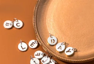 Macro detail of S925 sterling silver hollow alphabet letter pendants for DIY jewelry making