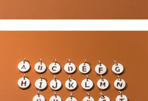 Close-up of S925 silver hollow round charms featuring A-Z alphabet cutouts