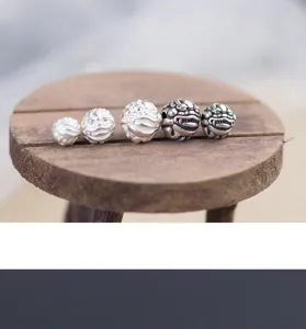 Macro-weergave van zilveren Pixiu-bedels in verschillende maten voor DIY-sieraden.