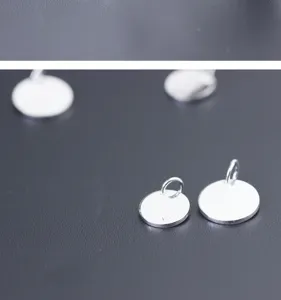 Detail of polished S925 sterling silver round tag charms with hallmark for DIY jewelry