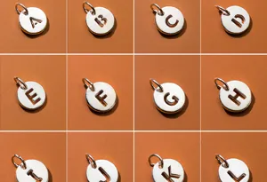 Detailed view of S925 sterling silver hollow round pendants featuring letters A to L