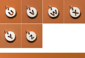 Close-up of S925 silver hollow alphabet pendants U to Z for DIY jewelry making.