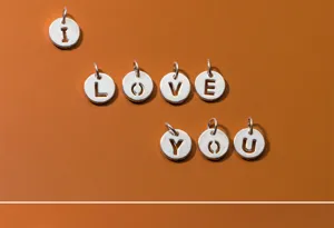 Detail view of S925 sterling silver hollow letter round pendants spelling I LOVE YOU