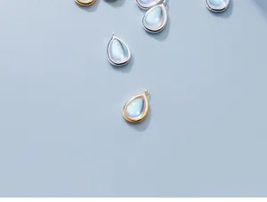 Macro view of teardrop moonstone pendants with premium silver and gold plated finishes