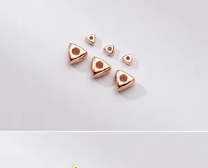 Detailed view of rose gold plated triangular spacer beads in two different sizes.