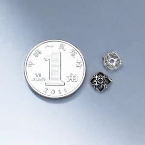 Gros plan de calottes de perles fleurs en argent S925 au design ajouré complexe