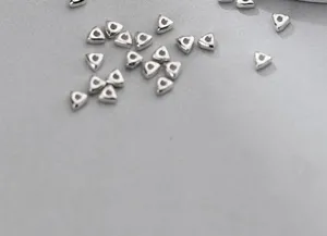 Close-up of S925 sterling silver triangular geometric spacer beads for DIY jewelry