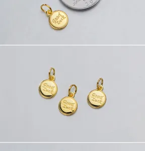 Detail shot of three golden Good Luck engraved round silver pendants for DIY jewelry
