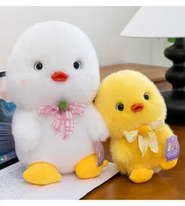 Detailed view of cute plush duck toys in white and yellow with soft fur and plaid bows.