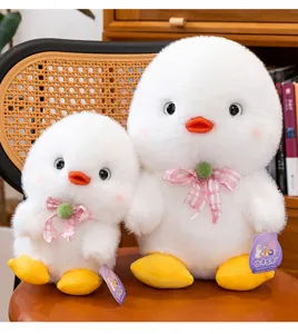 Detailed shot of two white fluffy duckling plush toys with pink checkered bow ties