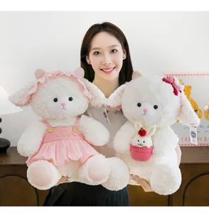 Cute white sheep plush toys with pink accessories held by a model in a warm indoor setting