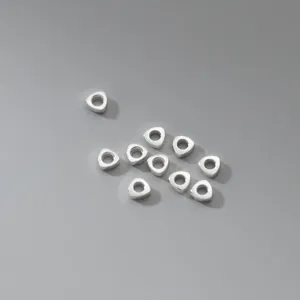 S925 sterling silver triangular spacer beads displayed on a neutral grey background