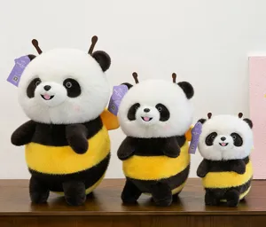 Detailed view of three sizes of cute bee-panda plush toys on a wooden table