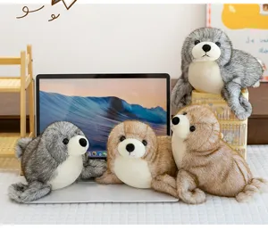 Grupo de realistas peluches de foca en gris y marrón alrededor de un portátil