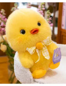 Detailed view of a cute yellow duck plush toy with a checkered bow sitting in a cozy basket