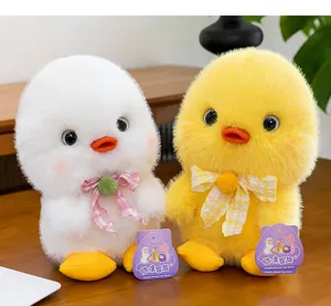 Close-up of fluffy white and yellow chick plush toys with cute bow ties on wood
