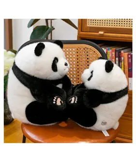Set of two realistic black and white panda plush toys sitting on a chair in a home