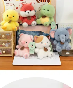 Collection of cute plush animal toys displayed on a desk with a laptop and decor
