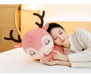 Primo piano di un morbido peluche a forma di renna rosa in un'accogliente camera da letto