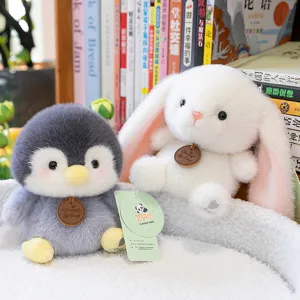 Cute plush penguin and white bunny animal toys on a cozy home bookshelf background.