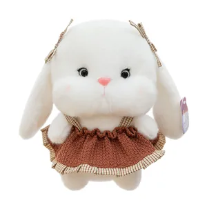 Adorable lapin en peluche blanc avec robe en tricot marron et nœuds