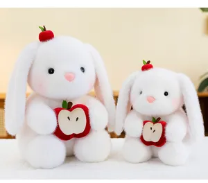 Detail van twee zachte witte pluche konijnen van verschillende groottes met appels