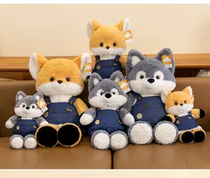 Group of fox and wolf plush toys in denim overalls sitting on a sofa