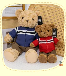 Detailed shot of cute plush teddy bears in knitted cardigans and pants, soft toy decor.