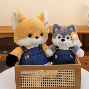 Adorable fox and wolf plush dolls wearing blue denim overalls inside a rustic wooden basket