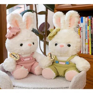 Macro view of white plush rabbit dolls wearing colorful corduroy overalls and hats