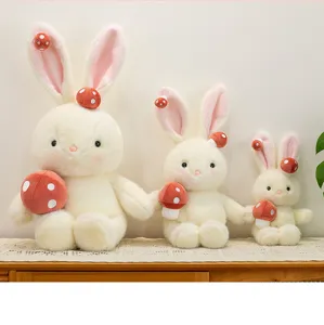 Tre dimensioni di simpatici peluche a forma di coniglio fungo bianco su mobile in pizzo