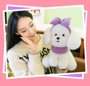 Close-up detail of a soft white plush dog toy featuring a purple bow and lace collar