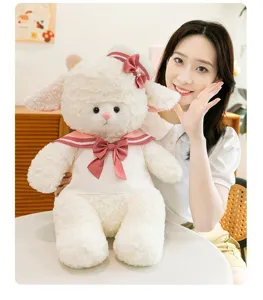 Detail shot of a cute white plush lamb toy wearing a pink sailor outfit and hat