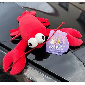 Close-up of a cute red lobster plush toy with large eyes on a glossy reflective surface