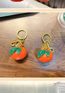 Close-up view of realistic resin tangerine keychains featuring detailed fruit skin texture